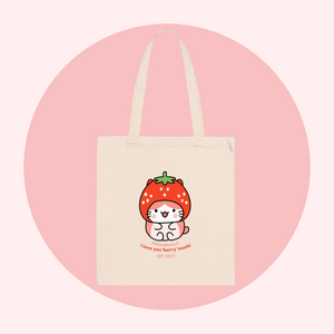 Tote bag with a cute cat design and strawberry on a pink background. There's a slogan that says ' I Love You Berry Much'