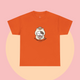 Bright orange t-shirt showcasing a kawaii cartoon cat holding a coffee cup, paired with the slogan “No talkie before coffee.” Fun and cheerful, part of The Linea Home Kitty Squad collection.