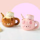 Two cute animal-themed mugs, one brown with a bear design and one pink with a bear design, on a light background.