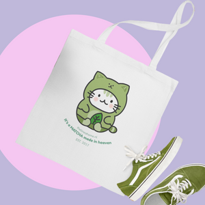 Tote bag with a green cat illustration and matching green sneakers on a purple and pink background
