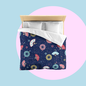 Bed with colourful fireworks in traditional Japanese pattern bedding with on a dark blue background. Several designs of Japanese paper fans are dotted around