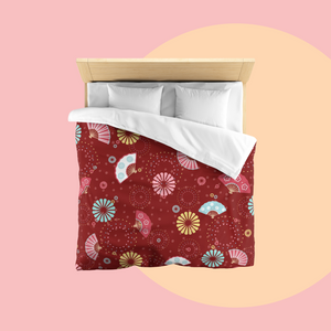 Bed with colourful fireworks in traditional Japanese pattern bedding with on a red background. Several designs of Japanese paper fans are dotted around