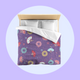 Bed with colourful fireworks in traditional Japanese pattern bedding with on a lavender purple background. Several designs of Japanese paper fans are dotted around