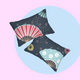 2 pillows with olourful fireworks in traditional Japanese pattern bedding with on a dark blue background. Several designs of Japanese paper fans are dotted around. Both pillows have different design
